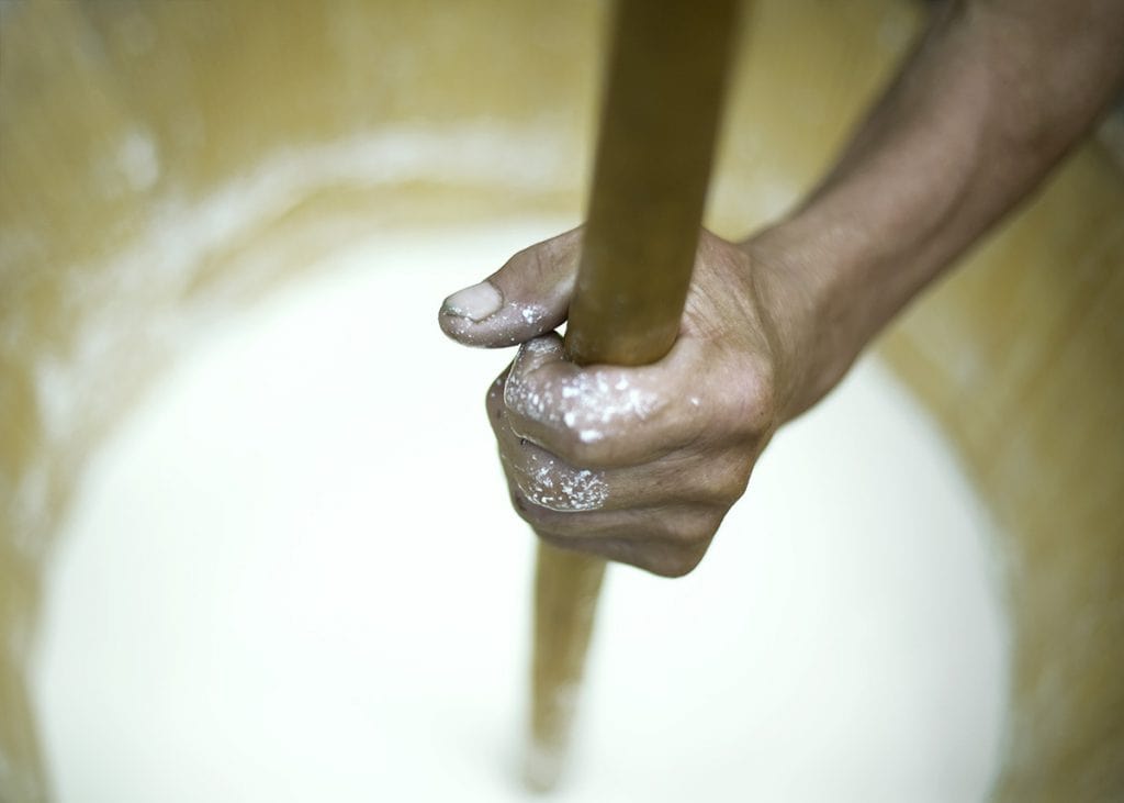Hand rührt Teig in einer Backform, Konditorei, Backkunst, handwerkliche Arbeit.