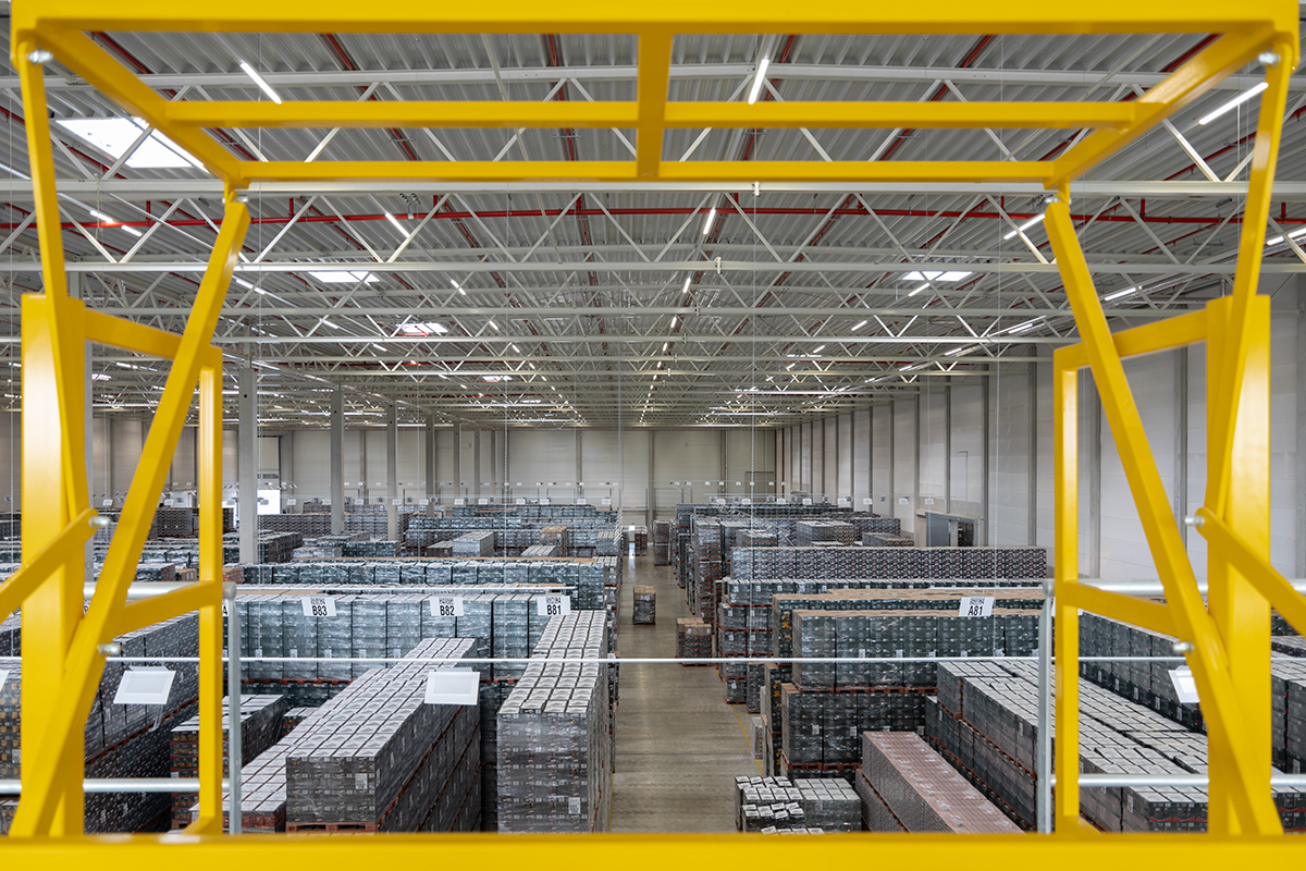 Riesige Lagerhalle eines Logistikunternehmens, von oben, knapp unter dem Hallendach fotografiert.